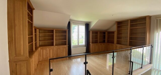 Réalisation de deux grandes bibliothèques asymétriques situées sur une mezzanine dont la toiture est mansardée